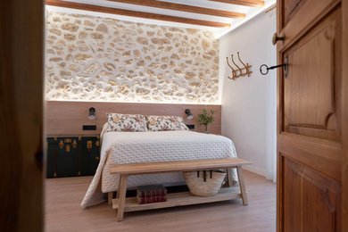 Foto de dormitorio principal, abovedado y blanco y madera de estilo de casa de campo de tamaño medio con paredes blancas, suelo de madera clara y suelo beige