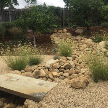 Stone slab bridge over dry creaked edged in native grass