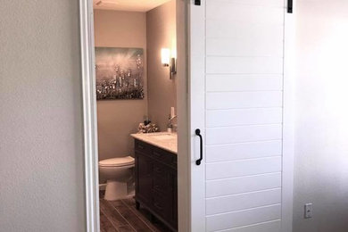 Photo of a medium sized traditional ensuite bathroom in Dallas with flat-panel cabinets, grey cabinets, an alcove shower, a two-piece toilet, white tiles, metro tiles, grey walls, porcelain flooring, a submerged sink, marble worktops, grey floors, a sliding door and grey worktops.