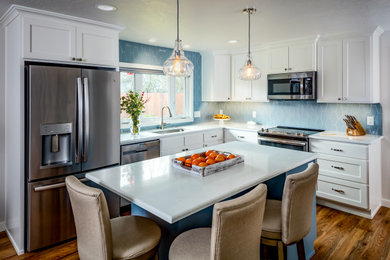 Mid-sized arts and crafts l-shaped laminate floor eat-in kitchen photo in Other with an undermount sink, shaker cabinets, white cabinets, quartzite countertops, blue backsplash, ceramic backsplash, stainless steel appliances, an island and white countertops