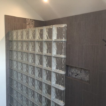 Straight glass block shower wall with a finished end block in a contemporary bat