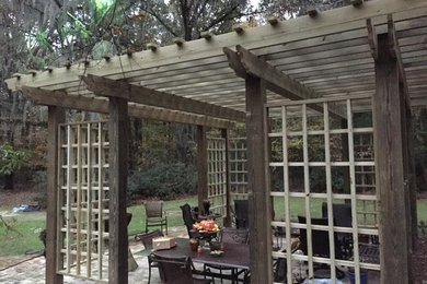 Mid-sized transitional backyard concrete patio photo in Jackson with a pergola