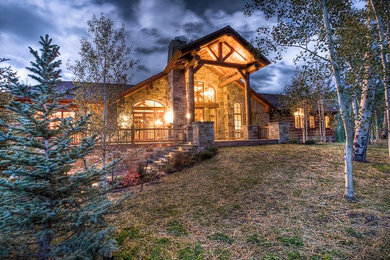 Example of a large mountain style multicolored two-story stone exterior home design in Denver with a shingle roof