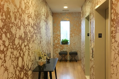 Example of a huge minimalist light wood floor hallway design in New York with white walls