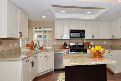 Open concept kitchen - mid-sized transitional u-shaped open concept kitchen idea in San Diego with an island, an undermount sink, raised-panel cabinets, white cabinets, granite countertops, beige backsplash, stone slab backsplash and stainless steel appliances