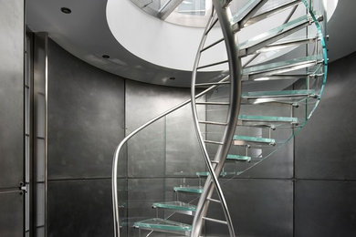Foto de escalera curva minimalista con escalones de vidrio y contrahuellas de vidrio