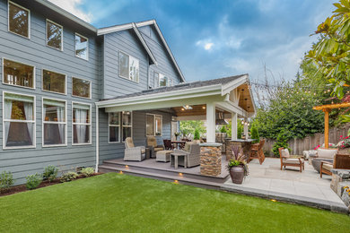 Large arts and crafts backyard patio kitchen photo in Seattle with a roof extension and decking