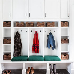 ニューヨークの大きいダッチドアカントリー風おしゃれなマッドルーム (白い壁、ライムストーンの床、黒いドア、黒い床) の写真