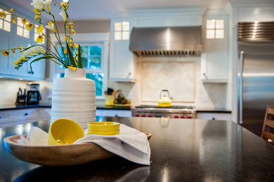 Large trendy l-shaped medium tone wood floor and brown floor kitchen photo in Calgary with shaker cabinets, white cabinets, beige backsplash, stainless steel appliances, an island, an undermount sink, soapstone countertops and stone tile backsplash