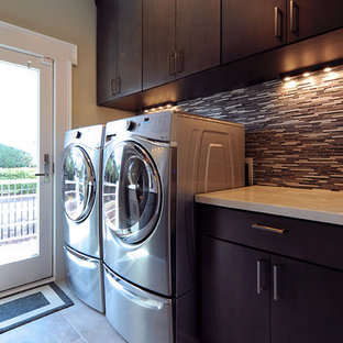 ワシントンD.C.の大きいコンテンポラリースタイルのおしゃれなランドリールーム (フラットパネル扉のキャビネット、濃色木目調キャビネット、クオーツストーンカウンター、セラミックタイルの床) の写真
