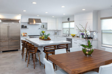 Inspiration for a large contemporary porcelain tile, gray floor and tray ceiling eat-in kitchen remodel in San Diego with a single-bowl sink, flat-panel cabinets, white cabinets, quartzite countertops, white backsplash, ceramic backsplash, stainless steel appliances, an island and white countertops