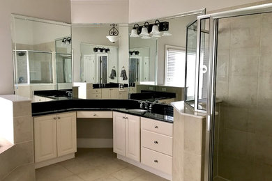 Inspiration for a large transitional master gray tile and marble tile porcelain tile and black floor bathroom remodel in Atlanta with shaker cabinets, white cabinets, granite countertops and a hinged shower door
