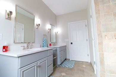 This is an example of a 3/4 bathroom in Detroit with grey cabinets, multi-coloured tile, ceramic floors and white benchtops.
