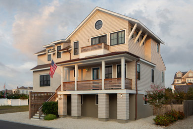 Mid-sized beach style beige three-story wood and shingle exterior home photo in New York with a brown roof