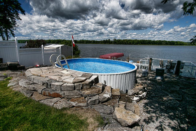 Inspiration for a small rustic stone and round aboveground pool remodel in Ottawa