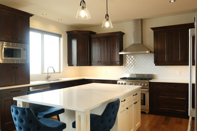 Cette photo montre une cuisine en U avec un plan de travail en quartz, une crédence blanche, un électroménager en acier inoxydable et un plan de travail blanc.