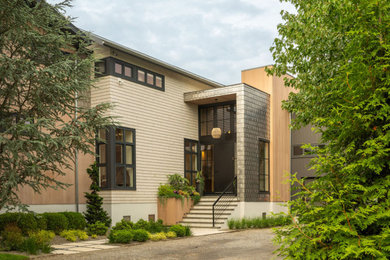 Inspiration for a mid-sized coastal beige two-story wood exterior home remodel in New York with a metal roof and a gray roof