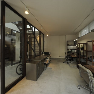 東京23区の小さいモダンスタイルのおしゃれなホームオフィス・仕事部屋 (白い壁、コンクリートの床、自立型机、グレーの床) の写真