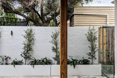 Mid-sized backyard rectangular pool in Melbourne with natural stone pavers.