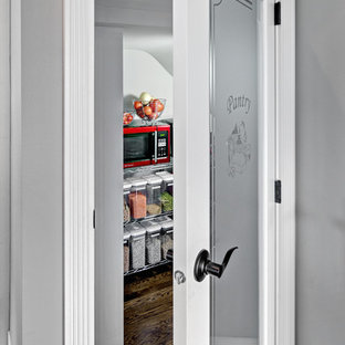 Idéer för mellanstora lantliga kök, med en undermonterad diskho, skåp i shakerstil, vita skåp, bänkskiva i täljsten, vitt stänkskydd, stänkskydd i keramik, integrerade vitvaror, mörkt trägolv och en köksö