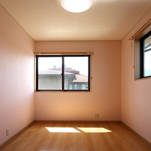 Immagine di una piccola camera da letto moderna con pareti rosa, pavimento in compensato e pavimento beige