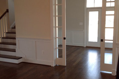 Photo of a large transitional front door in DC Metro with yellow walls, medium hardwood floors, a double front door and a white front door.