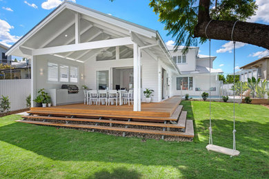 Large modern two-storey white house exterior in Brisbane with wood siding, a gable roof and a metal roof.