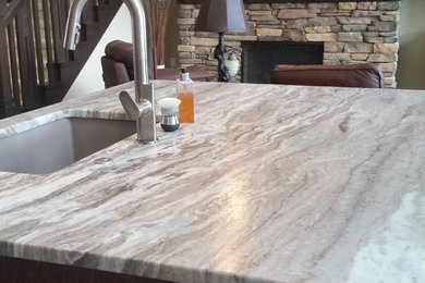 Large minimalist l-shaped medium tone wood floor and brown floor eat-in kitchen photo in Other with an undermount sink, raised-panel cabinets, medium tone wood cabinets, quartz countertops, multicolored backsplash, glass tile backsplash, stainless steel appliances and an island