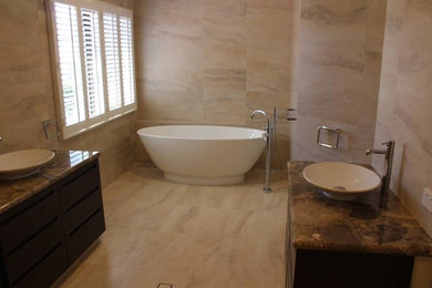 Inspiration for a transitional master bathroom in Perth with flat-panel cabinets, dark wood cabinets, a freestanding tub, a corner shower, beige tile, marble benchtops and an open shower.