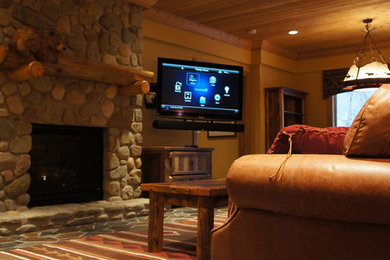 Family room - mid-sized rustic enclosed family room idea in New York with beige walls, a standard fireplace, a stone fireplace and a wall-mounted tv
