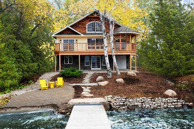 Inspiration for a mid-sized craftsman yellow two-story concrete fiberboard gable roof remodel in Vancouver