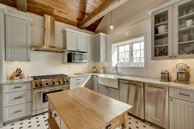 Example of a mid-sized country l-shaped porcelain tile and multicolored floor eat-in kitchen design in Other with a farmhouse sink, shaker cabinets, gray cabinets, marble countertops, white backsplash, subway tile backsplash, stainless steel appliances and an island