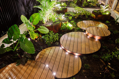 Small tropical courtyard shaded formal garden in Perth with decking.