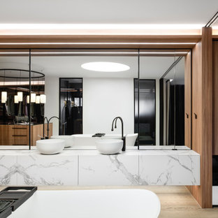 Expansive contemporary master bathroom in Sydney with a freestanding tub, a double shower, medium hardwood floors, a vessel sink, marble benchtops, a hinged shower door, an enclosed toilet, a double vanity and a floating vanity.