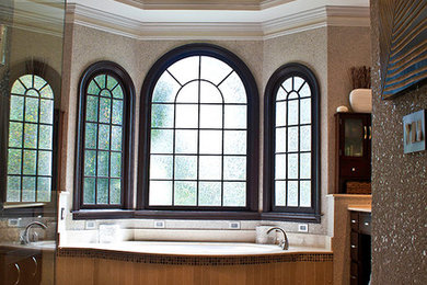 Corner shower - large transitional master beige tile and stone tile travertine floor corner shower idea in Atlanta with an undermount sink, flat-panel cabinets, dark wood cabinets, marble countertops, beige walls and an undermount tub