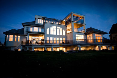 Photo of a large contemporary three-storey white exterior in Edmonton with a hip roof.