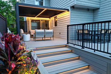 Inspiration for a mid-sized contemporary backyard ground level privacy and metal railing deck remodel in New York with a pergola