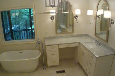 Photo of a large traditional ensuite bathroom in Birmingham with a freestanding bath, white walls, marble flooring, a submerged sink, white cabinets, an alcove shower, a two-piece toilet and a hinged door.