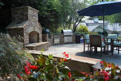 Example of a large mountain style backyard stone patio design in Atlanta with a fireplace