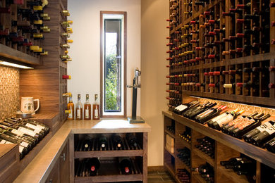 Contemporary wine cellar in Santa Barbara with storage racks and brown floor.