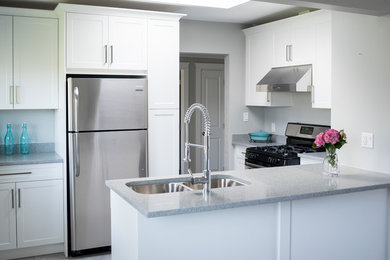 Small transitional porcelain tile eat-in kitchen photo in Vancouver with an undermount sink, shaker cabinets, white cabinets, quartz countertops, stainless steel appliances and a peninsula