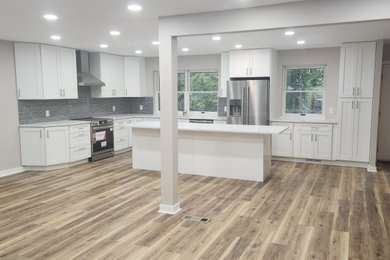 Eat-in kitchen - large l-shaped eat-in kitchen idea in Philadelphia with an undermount sink, white cabinets, quartz countertops, gray backsplash, ceramic backsplash, stainless steel appliances, an island and white countertops