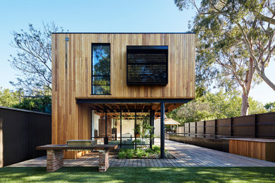 This is an example of a large modern two-storey house exterior in Melbourne with wood siding.