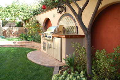 This is an example of a large mediterranean partial sun backyard brick formal garden in San Diego with a fire pit for spring.
