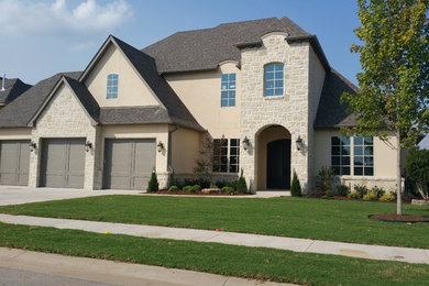Example of a large arts and crafts beige two-story stone house exterior design in Other with a hip roof and a shingle roof