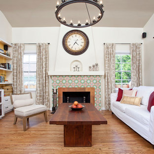 Modelo de salón para visitas cerrado, mediterráneo, de tamaño medio, con chimenea tradicional, marco de chimenea de baldosas y/o azulejos, pared multimedia, paredes beige y suelo de madera en tonos medios