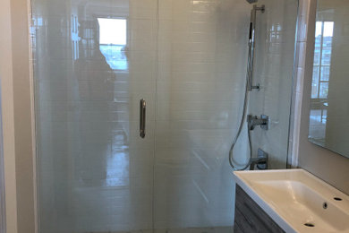 Alcove shower - small modern 3/4 white tile and ceramic tile ceramic tile, gray floor and single-sink alcove shower idea in New York with furniture-like cabinets, brown cabinets, a two-piece toilet, gray walls, quartz countertops, a hinged shower door, white countertops, a niche and a floating vanity