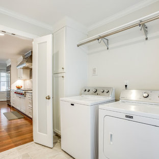 バーミングハムの中サイズのトランジショナルスタイルのおしゃれな洗濯室 (落し込みパネル扉のキャビネット、白いキャビネット、大理石カウンター、グレーの壁、磁器タイルの床、左右配置の洗濯機・乾燥機、グレーの床、マルチカラーのキッチンカウンター) の写真