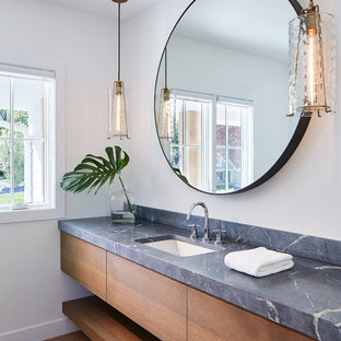 Idée de décoration pour une salle de bain nordique de taille moyenne avec un placard à porte plane, des portes de placard en bois brun, un mur blanc, un WC séparé, un sol en bois clair, un lavabo encastré, un plan de toilette en stéatite et un sol beige.