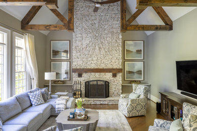 Example of a mid-sized trendy formal and enclosed medium tone wood floor living room design in Atlanta with beige walls, a standard fireplace, a metal fireplace and a wall-mounted tv